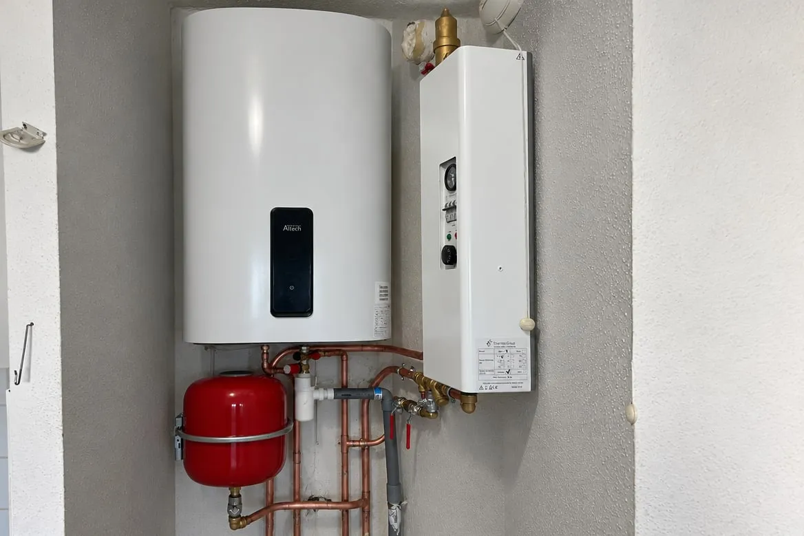 Niche après travaux : chaudière électrique Thermo Group, chauffe-eau Altech, vase d'expansion rouge et réseau refait en cuivre